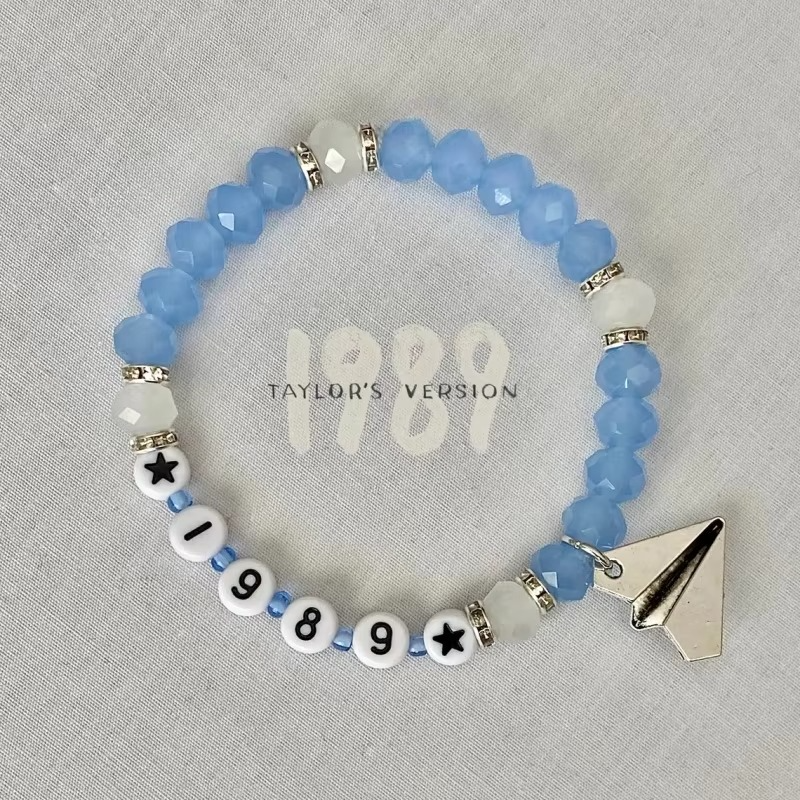 Beaded bracelet with '1989' and paper airplane charm