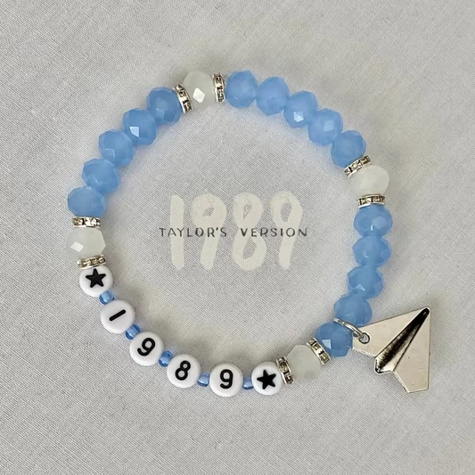 Beaded bracelet with '1989' and paper airplane charm