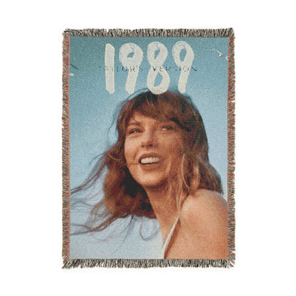 Woven blanket with a taylor swift's face and '1989' text on a blue background