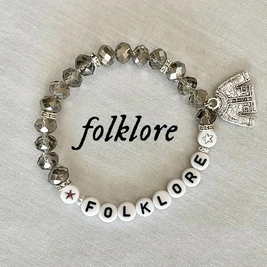 Bracelet with 'folklore' letters and a cardigan charm.