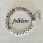 Bracelet with 'folklore' letters and a cardigan charm.